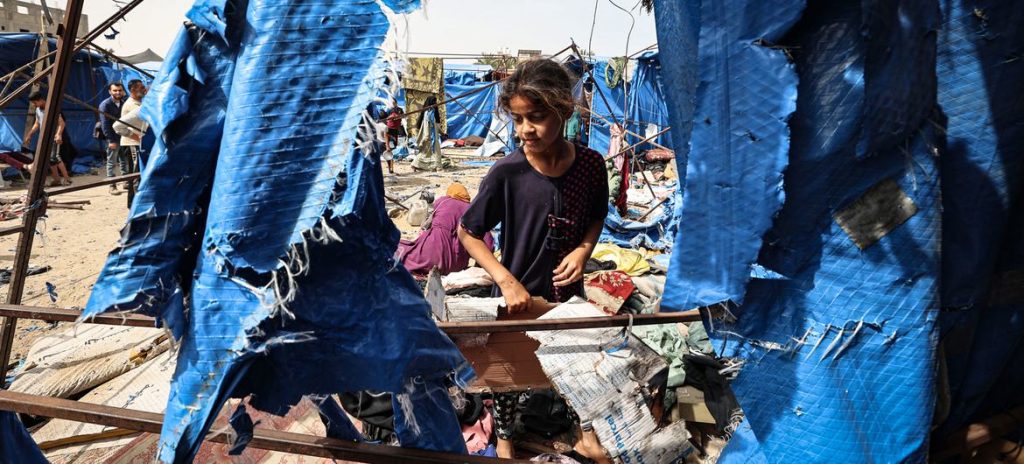 A young girl visits her tent which was destroyed following airstrikes in Deir al-Balah, Gaza.
