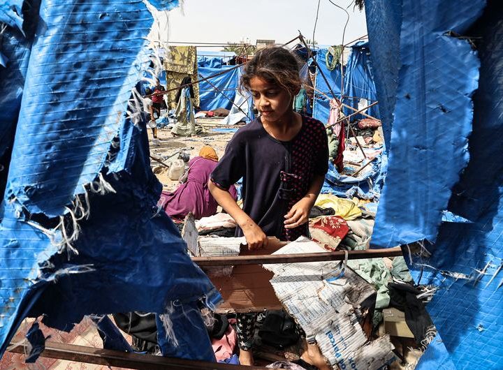 A young girl visits her tent which was destroyed following airstrikes in Deir al-Balah, Gaza.